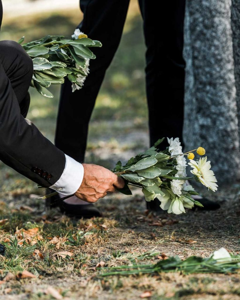 cropped-view-of-senior-man-putting-flowers-near-to-A4V7UQ3.jpg